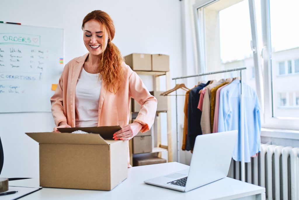 Young small business owner packing sold items and preparing deliveries