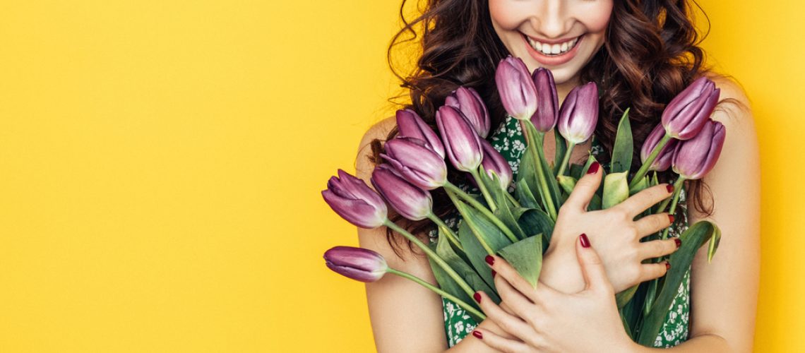 Lovely woman with purple tulips bunch